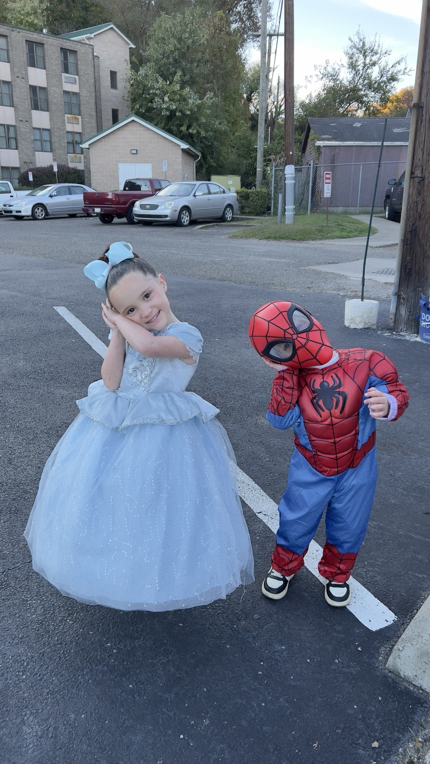 Two children dressed in a princess gown and Spider-Man costume before their Halloween evening